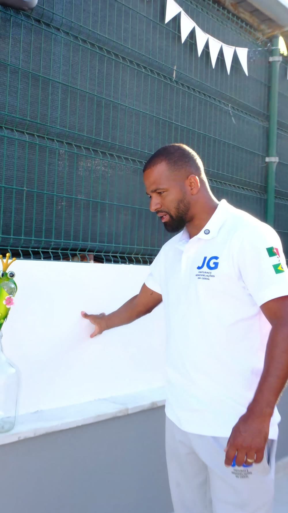 Gleidison Freitas a mostrar o acabamento branco liso de um muro terminado